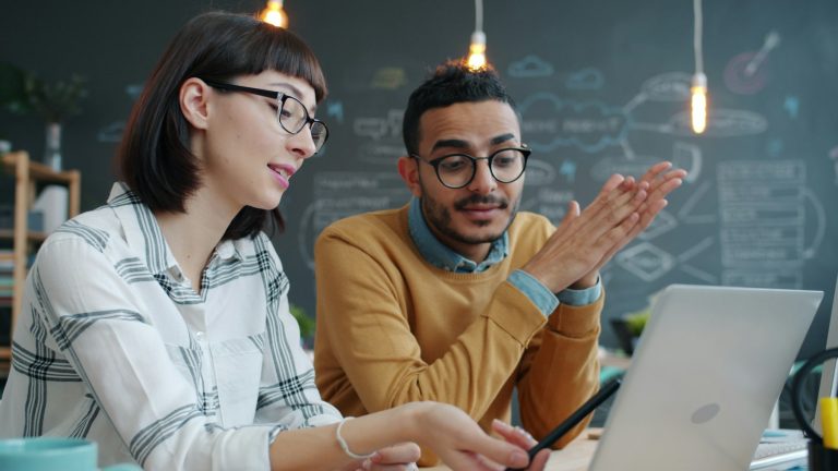Dos profesionales revisando juntos un proyecto en un portátil